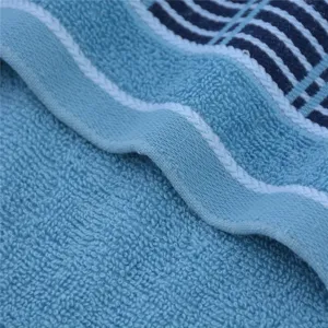 Close-up detail of soft cotton bath towel featuring terry loop texture and wide satin border.