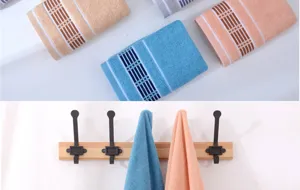 Detail view of thick absorbent pure cotton bath towels in various colors hanging and folded.