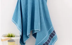 Detailed view of the soft blue cotton bath towel hanging gracefully with neat grid edge design.