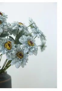 Detail shot of retro blue artificial sunflower bouquet in dark vase, floral home decor.