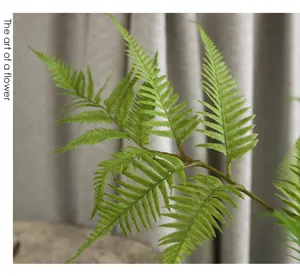 Close-up detail of artificial fern leaf, realistic green foliage branch for floral arrangements.