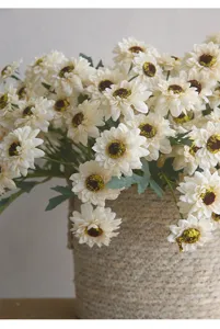 Close-up of vintage artificial daisy flower bouquet in woven basket for home decor.