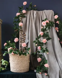 Artificial pink rose vine detail showing realistic silk flowers and lush green leaves.