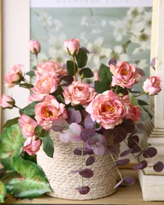 Primo piano dettagliato del bouquet di fiori di rose artificiali in vaso tessuto.