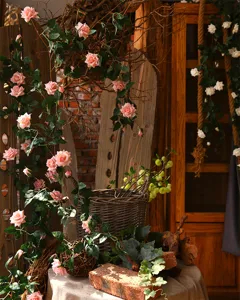 Detailed view of artificial pink rose vine decor, showing realistic floral texture and green leaves.