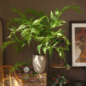 Artificial golden silk fern leaf plant in ceramic vase for home decor and landscape display.