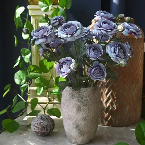 Elegant artificial ranunculus flower arrangement in vase for chic home table decor.