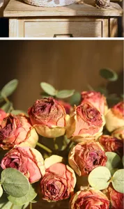 Detailed close-up view of vintage burnt-edge artificial roses and green eucalyptus leaves.
