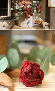 Close-up detail of vintage artificial red roses and eucalyptus leaves arrangement for home decor.