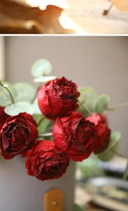 Detailed close-up shot of vintage burnt-edge artificial red roses and eucalyptus leaves.