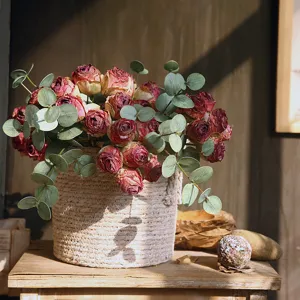 Vintage scorched-edge artificial rose bouquet with eucalyptus leaves in woven basket for home decor.