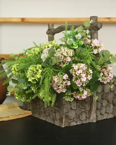 Detailed closeup of artificial hydrangea and snowball flower arrangement in rustic wooden planter.