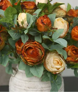 Detailed view of high-end European artificial burnt edge roses bouquet with green leaves in a vase.