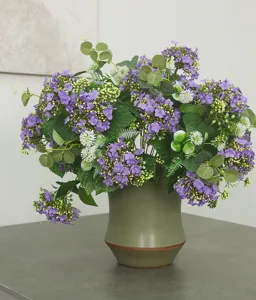 Detailed view of artificial purple snowball flower bouquet in ceramic vase for home decor.