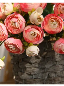 Artificial camellia flower detail, pink floral arrangement in woven basket for home decor.