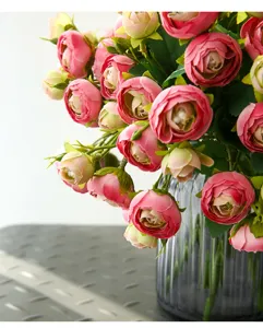 Pink artificial camellia flower bouquet in glass vase for home decor indoor detail.