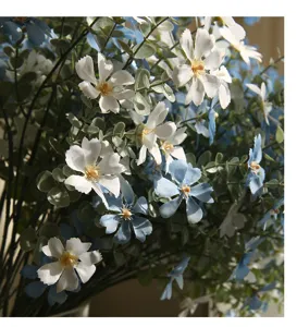 Nahaufnahme eines künstlichen Wildblumenstraußes mit realistischen Blütenblättern und Blättern.