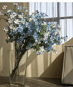 Künstlicher blau-weißer Wildblumenstrauß in Glasvase, ländlicher Stil Heimdekor Detail.