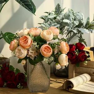 Bouquet de roses artificielles dans un vase en verre, élégant accessoire de déco nordique.