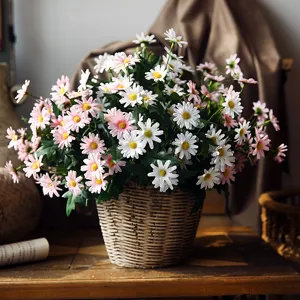 Piccoli fiori di margherita artificiali in cesto di vimini per decorare casa e fotografia