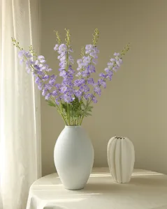 Artificial spring delphinium flowers in a white ceramic vase, perfect for home decor.