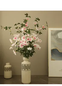 Artificial morning glory flowers in ceramic vase home decor faux floral arrangement.