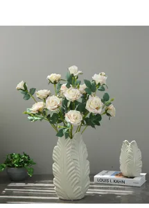 Detailed view of artificial rose bouquet arranged in leaf ceramic vase for home table decor.