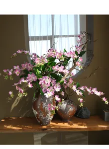 Detailansicht luxuriöser künstlicher Jasminblüten in Keramikvasen, edle Heimdekoration.