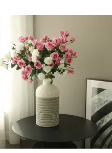 Detail shot of artificial rose flower arrangement and vase for home and living room decor.