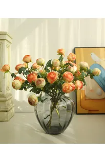 Dettaglio di un bouquet di rose artificiali in vaso di vetro grigio per la decorazione.