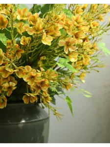 Detailed close-up of artificial yellow plum blossom branches, perfect for home decor display.