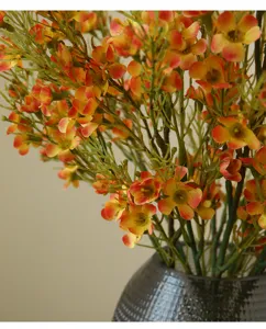 Artificial orange small flower bouquet detail shot for home decor photography props.