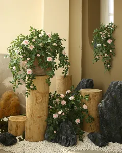 Artificial rose vine detail shot with pink flowers and green leaves for wall decor.