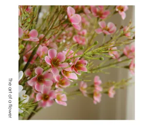 Close-up detail shot of artificial pink wax flower bouquet showing delicate petals and stems.
