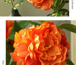 Detalle de flor de peonía artificial, pétalos de naranja vibrantes con hojas verdes realistas.