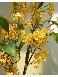 Close up of artificial yellow flower branch, detailed fake floral stem for home decor.