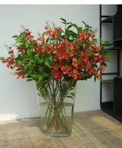 Elegant artificial wax flower bouquet in glass vase for home interior decor and wedding props.
