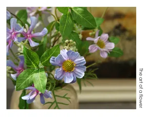 Primo piano dettagliato di fiori artificiali margherite viola con foglie, arredamento.