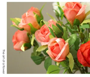 Detailed close-up of artificial champagne rose silk flowers bouquet with realistic green leaves.