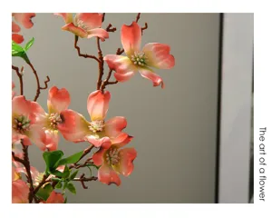 Artificial dogwood branch detail, pink faux flower arrangement for home decor, realistic floral.