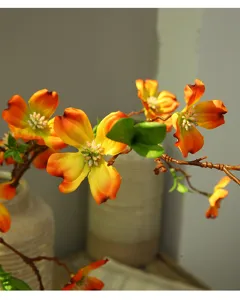 Detailed view of long branch artificial dogwood flowers in warm orange, perfect for home decor.