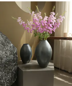 Detail view of artificial larkspur flowers in dark vases, perfect for modern home decor.