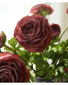 Dettaglio fiore ranuncolo artificiale, decoro floreale in seta rossa per salotto moderno.