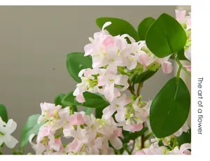 Close-up detail of artificial sweet osmanthus flowers with pink petals and green leaves.