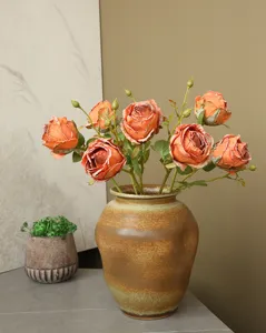 Detail view of vintage artificial rose flower arrangement in ceramic vase for retro home decor.