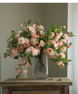 Beautiful artificial camellia flower arrangement in glass vase for home decor detail view.