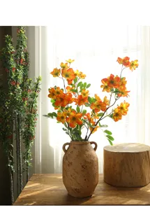 Composizione di fiori di begonia finti in vaso di ceramica per decorazione tavola.