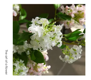 Detailed close-up shot of artificial jasmine flower cluster featuring vibrant green leaves.