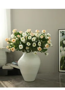 Gros plan de la composition de roses artificielles en céramique blanche pour la décoration intérieure.