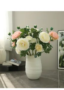 Artificial ranunculus flower bouquet in white ceramic vase for home decor interior styling.